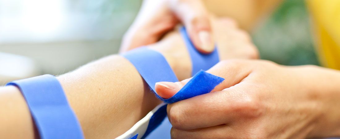 Behandlungssituation: Arm wird bandagiert Behandlungssituation: Arm wird bandagiert